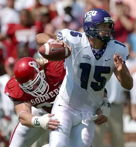 TCU quarterback Tye Gunn (15) gets a pass off while in the grasp of Oklahoma defender Dusty Dvoracek (94) Saturday, Sept. 3, 2005, in Norman, Okla. Gunn completed the pass for a touchdown. (AP Photo/Jerry Laizure)