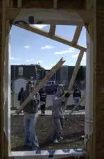 Karissa Hill and Casey Glass help put up the frame of the house.