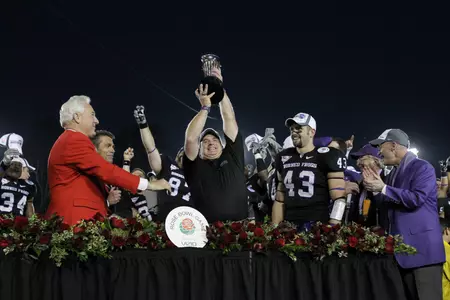 TCU football coach Gary Patterson hoisting the Rose Bowl Championship Trophy.