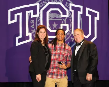 Jason Verrett receiving his Dan Rogers Most Valuable Player ring from Gary and Kelsey Patterson.