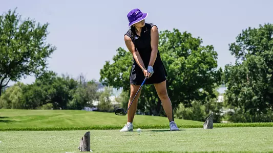 Kirstin Angosta gazes down the fairway as she prepares to hit a tee shot.