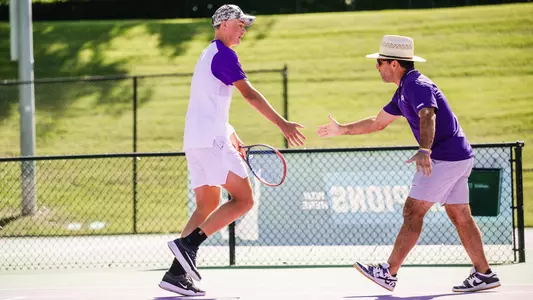 Maximus Dussault and David Roditi high five during the doubles point in a match vs. Cornell