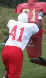 Martrel Brown hits the tackling dummy during Tuesday's practice.