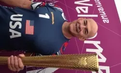 Coach Alejo holds the Olympic relay torch.