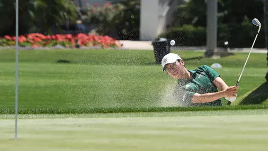 Austin Liu hits his ball out of a sand trap.