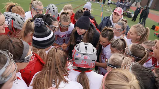 Women's lacrosse huddling for a pre-game pep talk