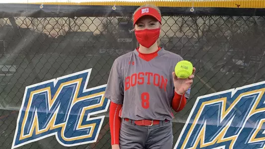 Allison Boaz poses with the softball in front of Merrimack's chained link fence after she threw a no-hitter.