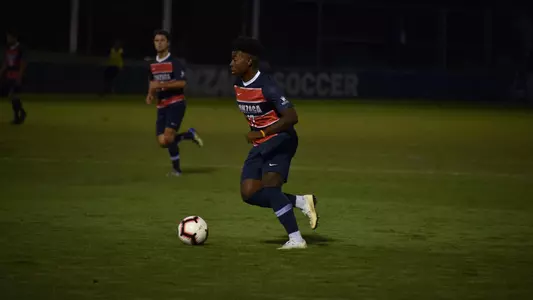 Demitrius Kigeya dribbles ball forward