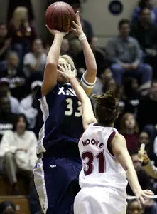 Xavier's Tara Boothe attempts a jump shot while being guarded by Temple's Ari Moore during the first half.