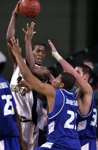 Dokun Akingbade passes the ball in front of Saint Louis' Justin Johnson and Luke Meyer. (AP Photo)