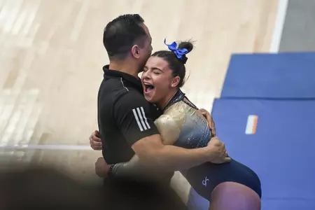 Crasa hugs volunteer assistant coach Justin Watson after vault.