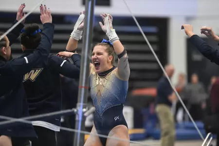 Banen celebrates uneven bars routine.
