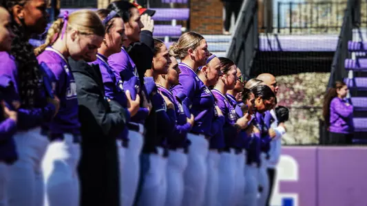 Dukes softball players lined up for anthem.