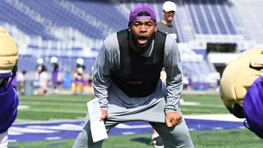 Terron Carey coaches the offensive line during a drill at a JMU football practice