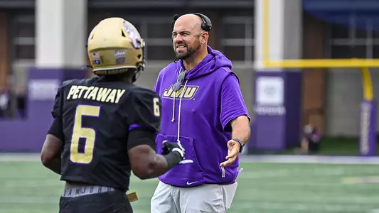 Rob Sale high fives a player during JMU's game against Wagner