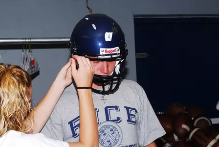 Freshman Randy Kitchens has some adjustments made to his new helmet.