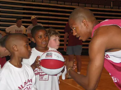 Aurealious Echols and Rufus Benson get instruction from Crimson Tide forward Evan Brock