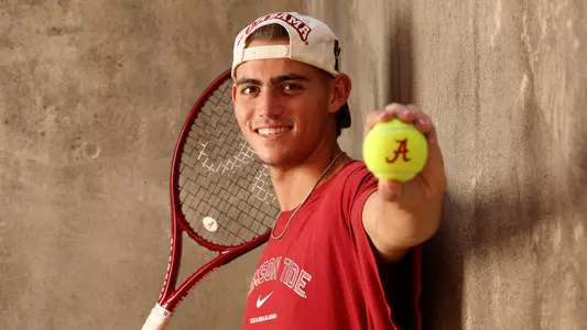 Zach Foster holding a tennis ball and racket 