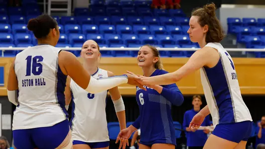 Members of the Seton Hall volleyball team celebrate after a point against Iona on Sept. 5