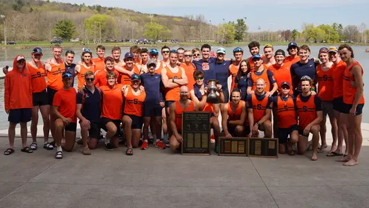 The Syracuse men's rowing team poses with the Goes Trophy and Stagg Trophy after winning both for a third-straight time. 