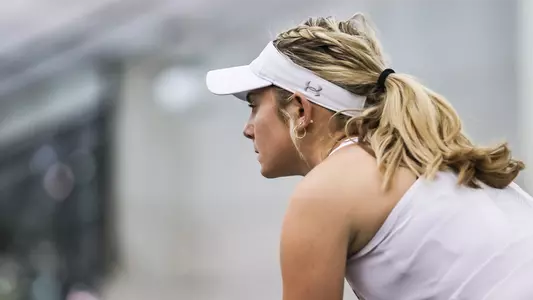 UNF Women's Tennis action shot with Anslee Long focused on the match.