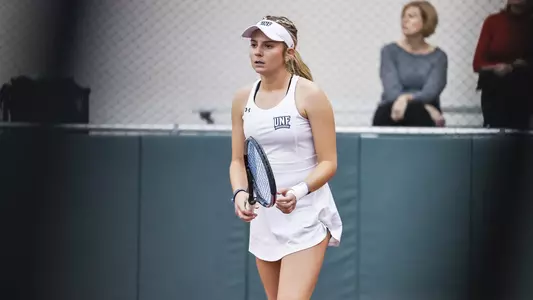UNF Women's Tennis action shot with Anslee Long playing on the court.
