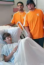 Michael Rivera and Sean Watson visit with a child at East Tennessee Children's Hospital