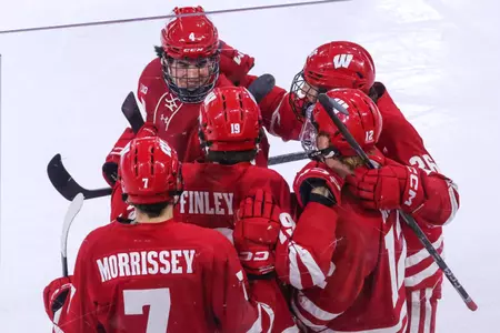 The Wisconsin men's hockey team celebrates scoring a goal 