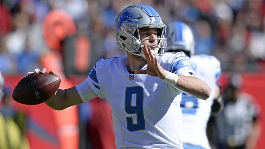 Georgia quarterback Matthew Stafford holds up his Detroit Lions