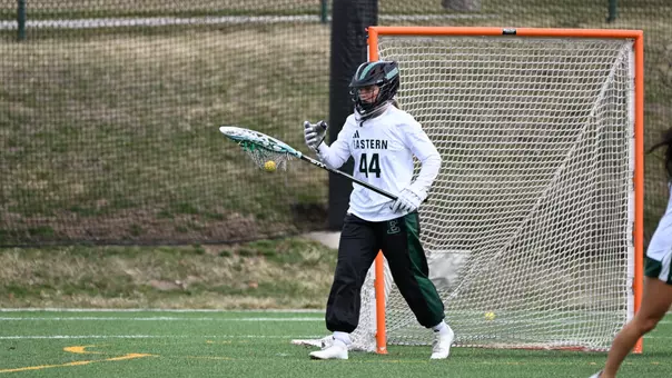 Maddy Porter carries the ball in her stick away from the goal as she instructs the defense to prepare for a clearing attempt against Kent State