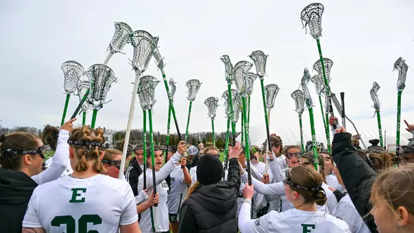 The lacrosse team puts their sticks in the air ahead of taking the field against Kent State