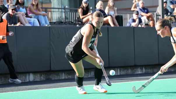 Carly van Benten lifts the ball into the air with her stick to avoid a tackle by a Georgetown defender