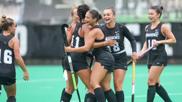 The Providence College field hockey team celebrates a goal scored by Lily Procaccianti during the team's win over Merrimack.