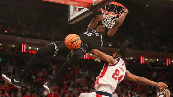 Oswin Erhunmwunse dunks the ball over defender at Madison Square Garden at St. John's.