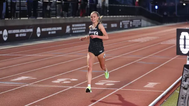 Women's track runner Anna Gardiner winning a race at the Friar Invitational