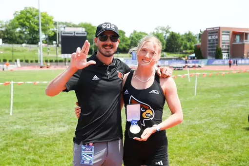 Lucy Fellows and Wyatt Rhoads pose with Fellows' gold medal at the 2026 ACC Outdoor Championships.