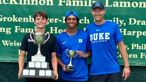 Duke men's tennis' Yannick Alexandrescou, Saahith Jayaraman and Ramsey Smith hold trophies and celebrate a successful Battle of the Bay 2026.