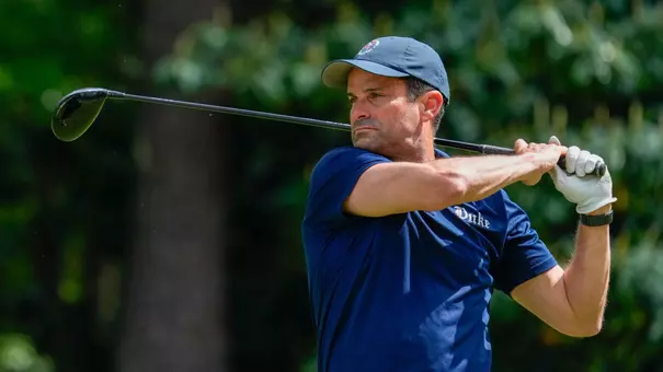 Duke head football coach Manny Diaz takes a golf swing during a charity event.
