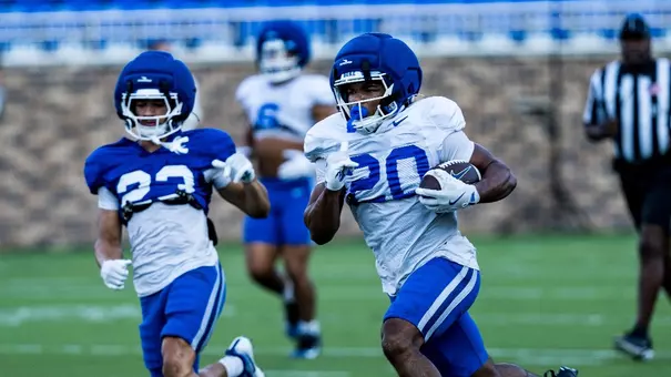 Duke running back Nate Sheppard, wearing a white jersey and blue pants, runs with the ball in his arms during a fall camp scrimmage on August 22, 2026.