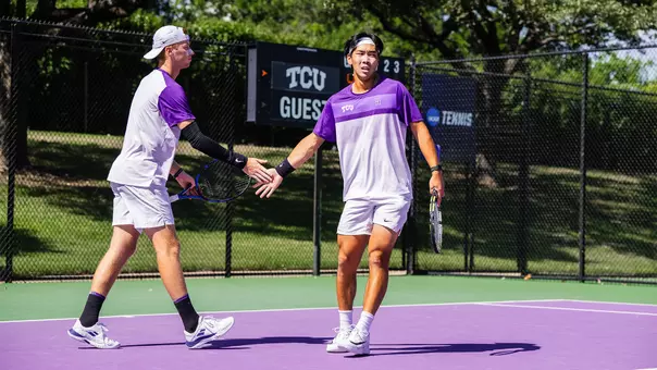 Cosme Rolland De Ravel and Duncan Chan high five during a doubles match.