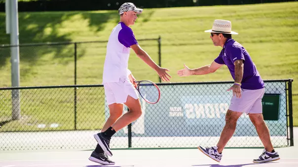 Maximus Dussault and David Roditi high five during the doubles point in a match vs. Cornell