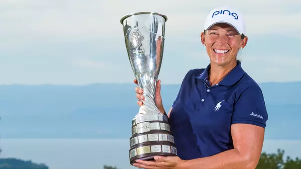 Angela Stanford holds the silver Evian Championship trophy wearing a blue shirt