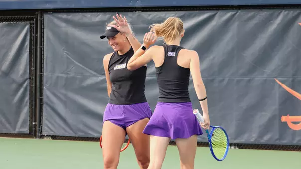 Anna Kantor and Corinna Riettman high five after a doubles point at the Wahoowa Invitational