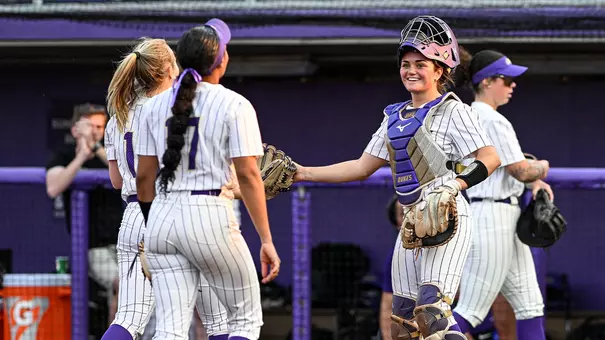Softball players high five after a win.