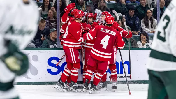 The Badger men's hockey team celebrates a goal at Michigan State
