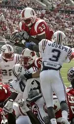 Louisville's Kolby Smith (33) dives over the pile to score from one-yard out against Florida Atlantic during second quarter of action at Cardinal Stadium in Louisville, Ky., Saturday, Oct. 1, 2005. Leading the way is Louisville's Breno Giacomini (89) moving FAU's Cergile Sincere (45) out of the way. At right is FAU's Greg Joseph (3). (AP Photo/Garry Jones)