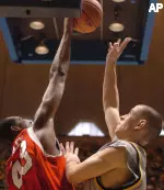 Louisville's Terrance Farley (43) blocks a shot by West Virginia's Alex Ruoff (22) during first half basketball action Tuesday Jan. 17, 2006 at the WVU Coliseum in Morgantown, W.Va. (AP Photo/Dale Sparks)