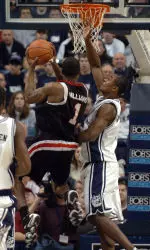 Louisville's Terrence Williams is guarded by Connecticut's Hilton Armstrong, right, in the first half of a college basketball game in Storrs, Conn., Saturday, March 4, 2006. (AP Photo/Jessica Hill)