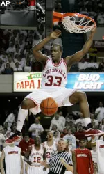 Andre McGee hangs on the rim after dunking the ball