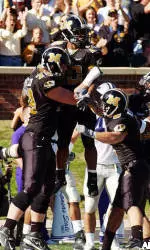 Missouri teammates hold up running back Marcus Woods.